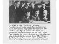 Men in suits in 1939 sitting around table looking at maps