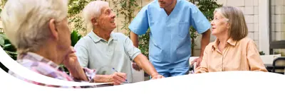 Image of a group of people chatting with each other and a healthcare worker.