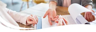 Image of two people having a conversation and filling out documents.