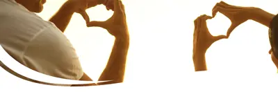 People with hands raised making the shape of a heart with their hands.