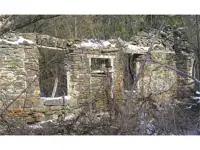 Partially fallen-down stone walls of an old farm house