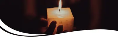 Image of a person holding a lit candle