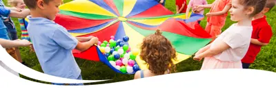 Image of children playing with a colourful parachute and balls.